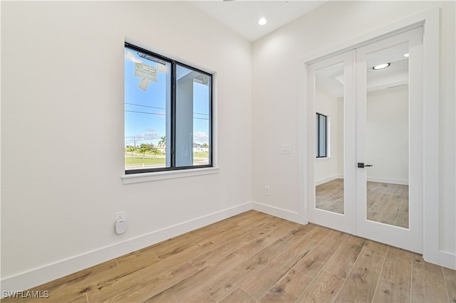 empty room with french doors and light wood-type flooring