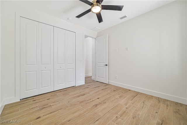 unfurnished bedroom with light hardwood / wood-style flooring, a closet, and ceiling fan