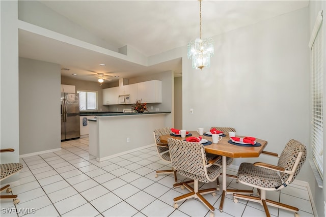 dining space featuring lofted ceiling, light tile patterned floors, and ceiling fan with notable chandelier