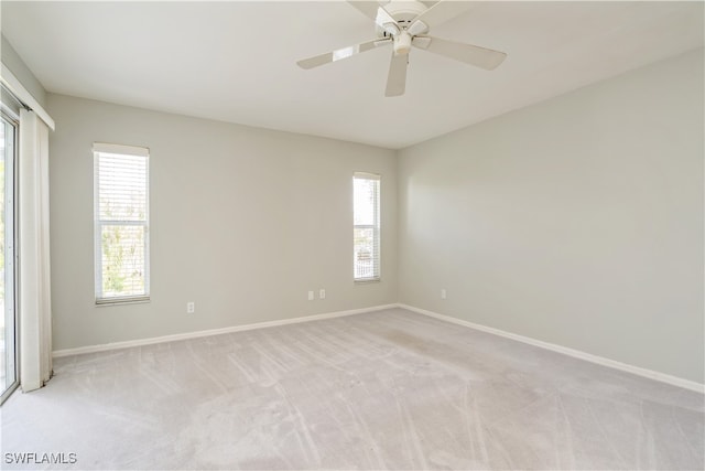 carpeted empty room with a healthy amount of sunlight and ceiling fan