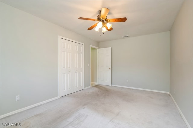 unfurnished bedroom with a closet, ceiling fan, and light carpet