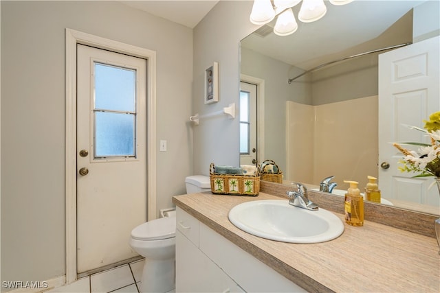 bathroom with vanity, a shower, toilet, and tile patterned floors