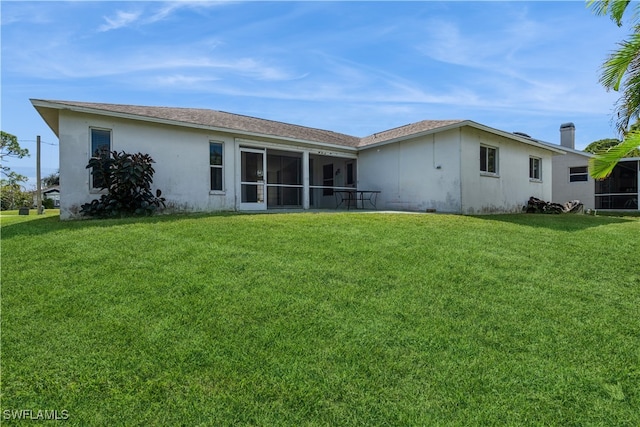 back of property featuring a sunroom and a lawn