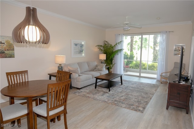 living room with ornamental molding, light wood-type flooring, and ceiling fan