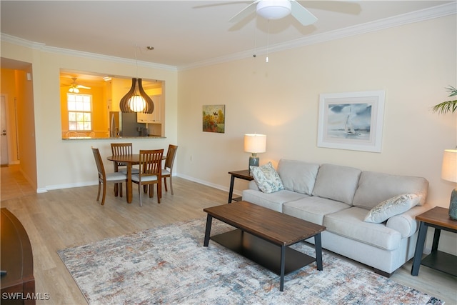 living room with crown molding, light wood-type flooring, and ceiling fan