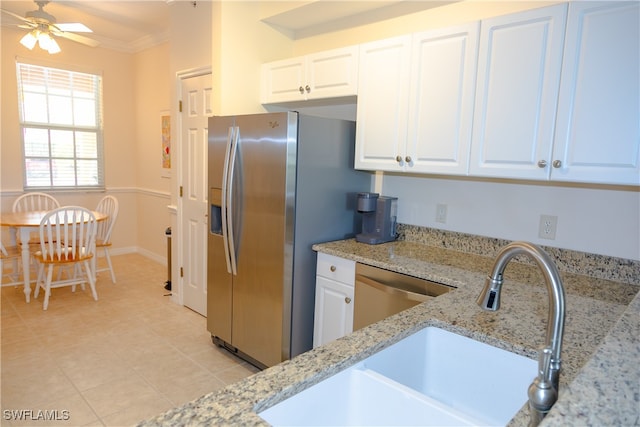 kitchen featuring sink, light stone counters, stainless steel appliances, white cabinets, and crown molding