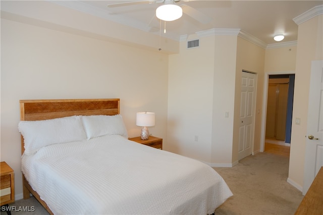 carpeted bedroom with a closet, ceiling fan, and ornamental molding