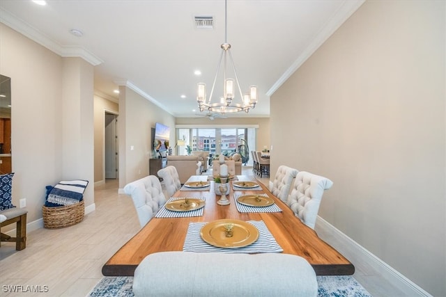 dining room with a chandelier, visible vents, crown molding, and baseboards