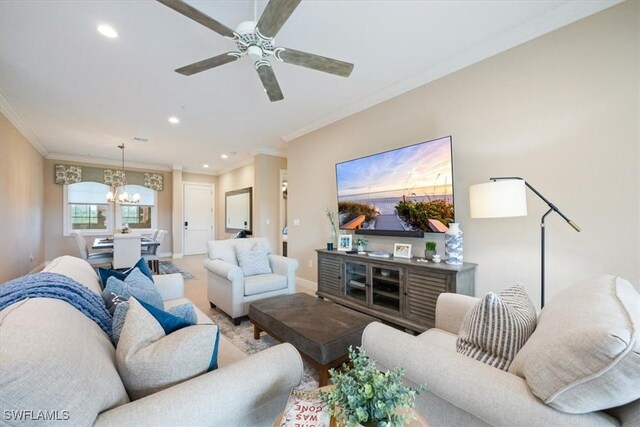 living room with ceiling fan with notable chandelier and ornamental molding