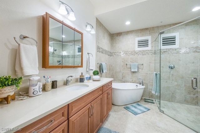 bathroom with visible vents, a shower stall, vanity, tile patterned flooring, and a freestanding tub