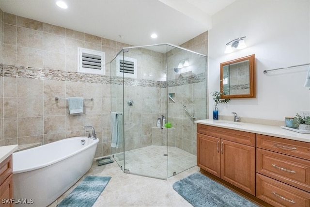 bathroom featuring a stall shower, a freestanding tub, vanity, and tile patterned floors