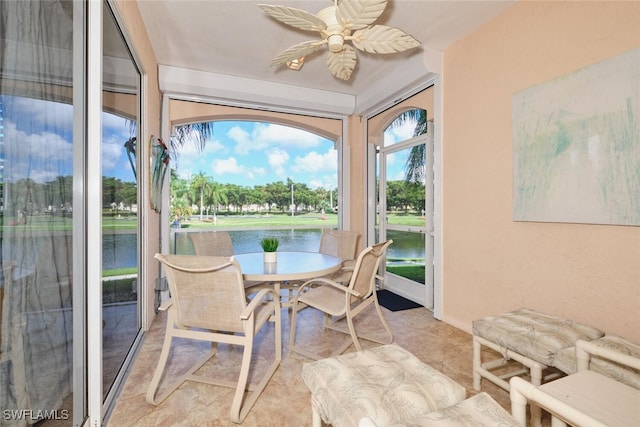 sunroom / solarium with a water view and ceiling fan