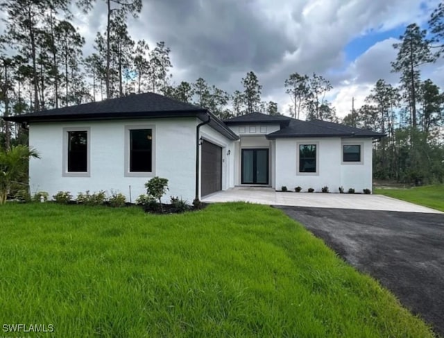 view of front of home with a front yard and a garage