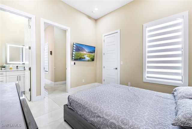 bedroom featuring ensuite bathroom, sink, and light tile patterned floors