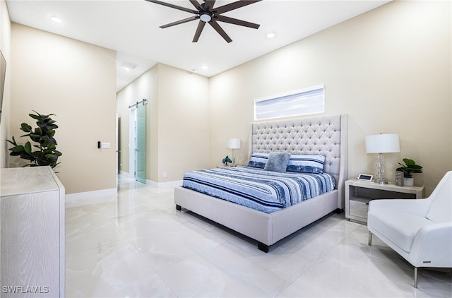 bedroom with a barn door and ceiling fan