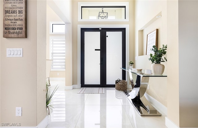 entrance foyer featuring french doors and light tile patterned floors