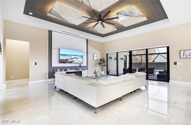 living room featuring a tray ceiling and ceiling fan