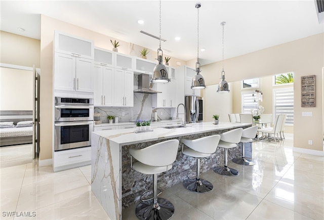 kitchen with a center island with sink, appliances with stainless steel finishes, and white cabinets