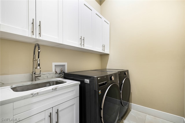 laundry room with cabinets, sink, washing machine and dryer, and light tile patterned floors