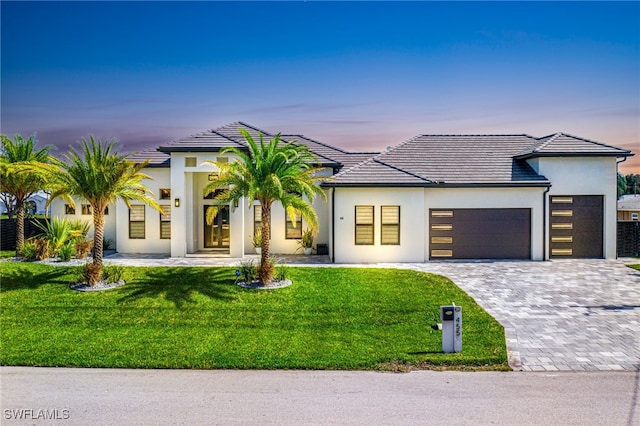 view of front of house featuring a yard and a garage