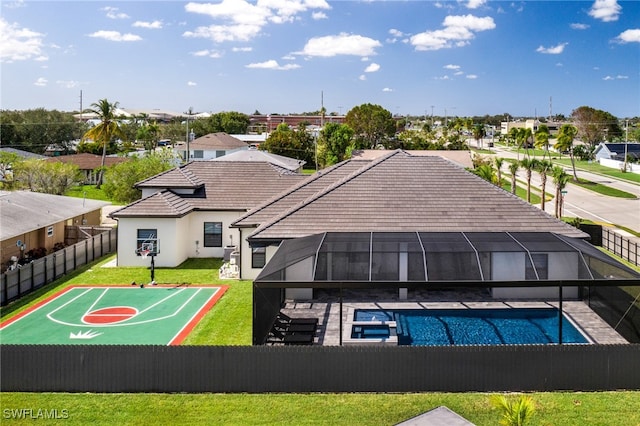 exterior space with basketball court, a lawn, a lanai, a patio area, and a fenced in pool