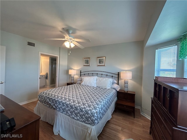 bedroom with ensuite bathroom, hardwood / wood-style flooring, and ceiling fan