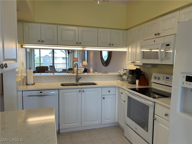 kitchen with white appliances, light tile patterned floors, sink, and white cabinets