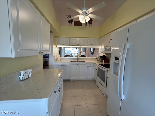 kitchen with white appliances, light tile patterned flooring, sink, white cabinetry, and vaulted ceiling