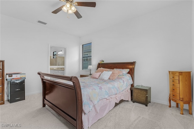 bedroom with connected bathroom, light carpet, and ceiling fan