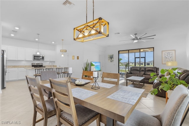 dining area featuring ceiling fan, sink, and light tile patterned floors