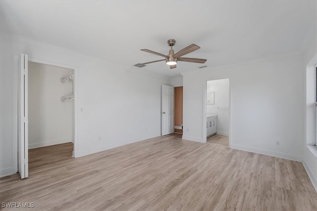 unfurnished bedroom featuring ceiling fan, light hardwood / wood-style floors, a spacious closet, and a closet