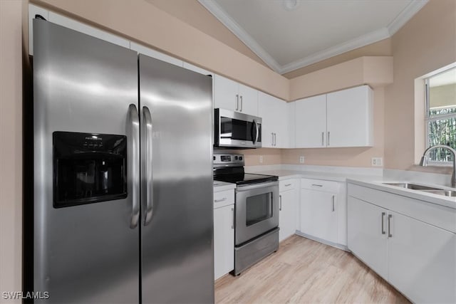 kitchen with sink, light hardwood / wood-style floors, vaulted ceiling, white cabinets, and appliances with stainless steel finishes