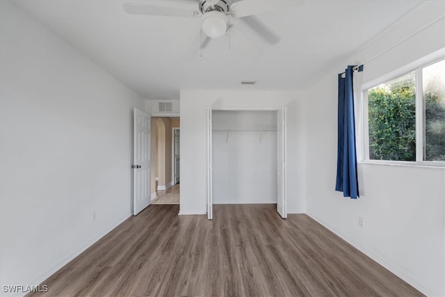 unfurnished bedroom with hardwood / wood-style floors, ceiling fan, and a closet