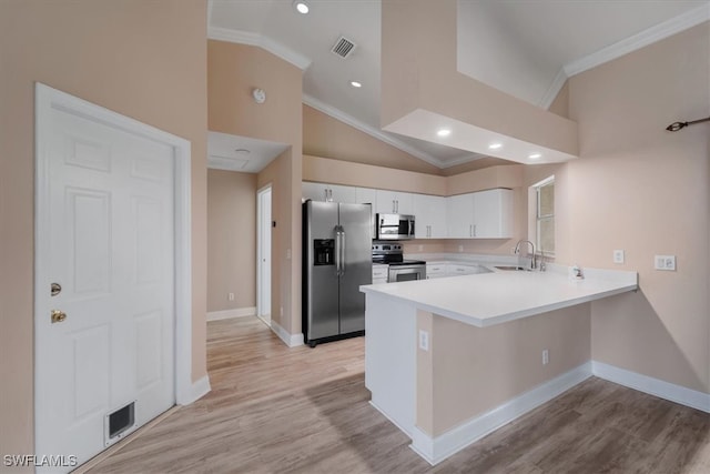 kitchen with white cabinetry, sink, kitchen peninsula, appliances with stainless steel finishes, and ornamental molding