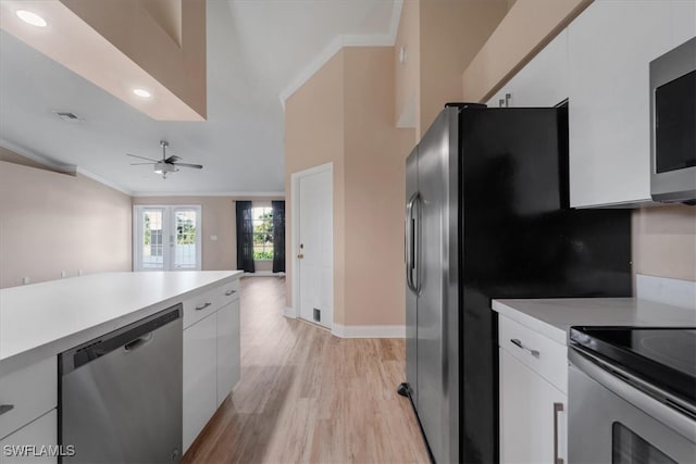 kitchen featuring french doors, crown molding, ceiling fan, white cabinetry, and stainless steel appliances