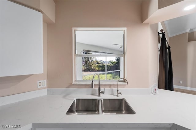 kitchen featuring light stone countertops, lofted ceiling, and sink