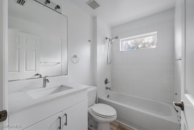 full bathroom featuring toilet, hardwood / wood-style floors, vanity, and tiled shower / bath combo