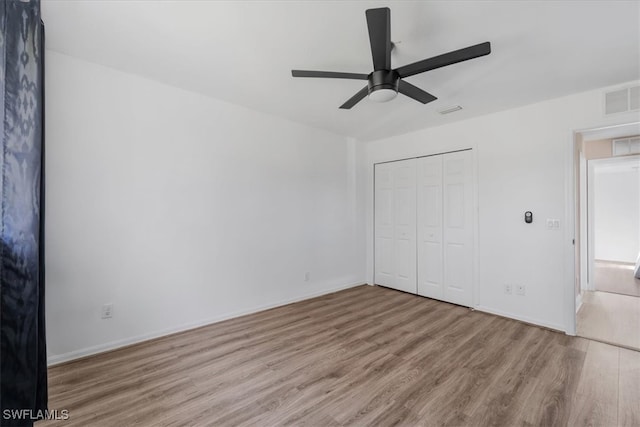 unfurnished bedroom featuring ceiling fan, a closet, and light hardwood / wood-style flooring