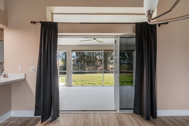 doorway to outside featuring ceiling fan and light wood-type flooring