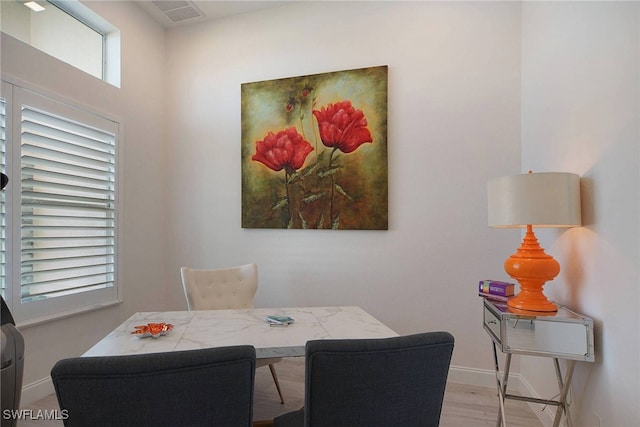 dining area with light hardwood / wood-style flooring and a healthy amount of sunlight