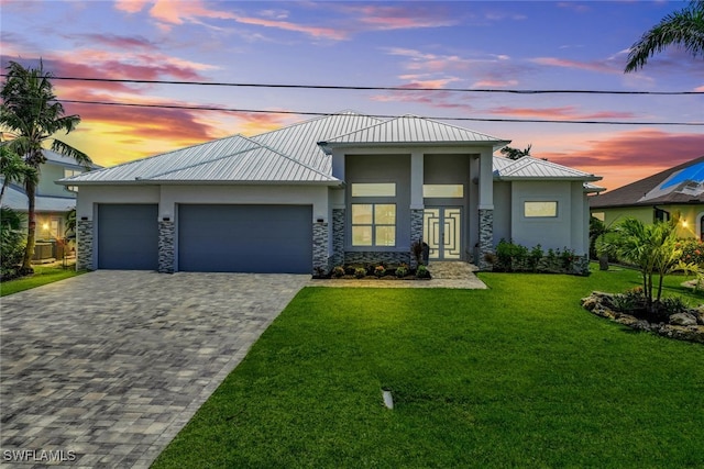 view of front of house featuring a garage and a lawn