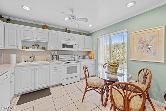 kitchen featuring white appliances, crown molding, sink, white cabinetry, and light tile patterned flooring