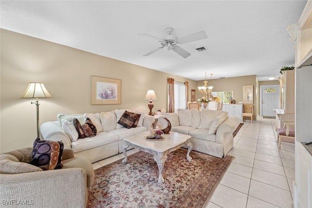 tiled living room with ceiling fan with notable chandelier