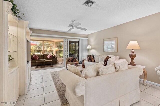 tiled living room featuring ceiling fan and a textured ceiling