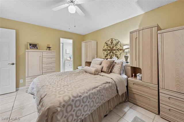 bedroom with ceiling fan, light tile patterned floors, and a textured ceiling