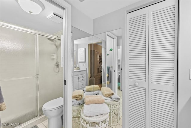 bathroom featuring tile patterned floors, vanity, toilet, and walk in shower