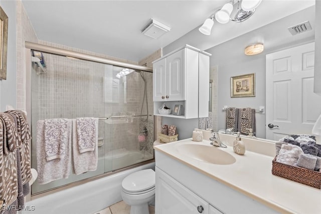 full bathroom featuring tile patterned flooring, vanity, bath / shower combo with glass door, and toilet