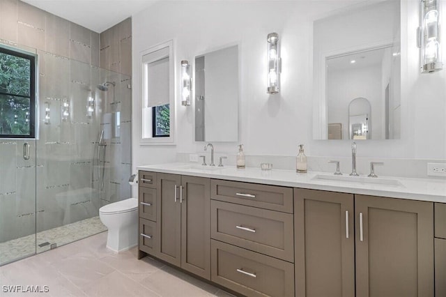 bathroom featuring a shower with door, vanity, and toilet