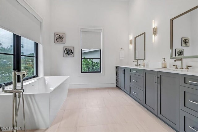 bathroom featuring vanity, tiled tub, and tile patterned flooring