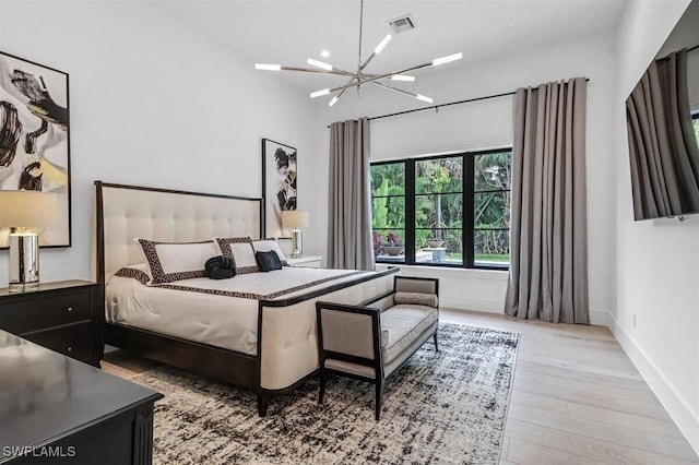 bedroom with an inviting chandelier and light wood-type flooring